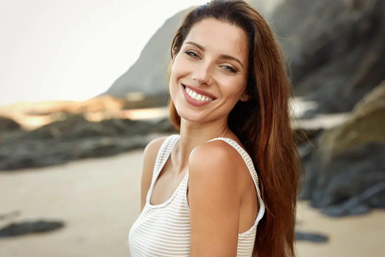 Beautiful smiling woman spends time on the beach CO