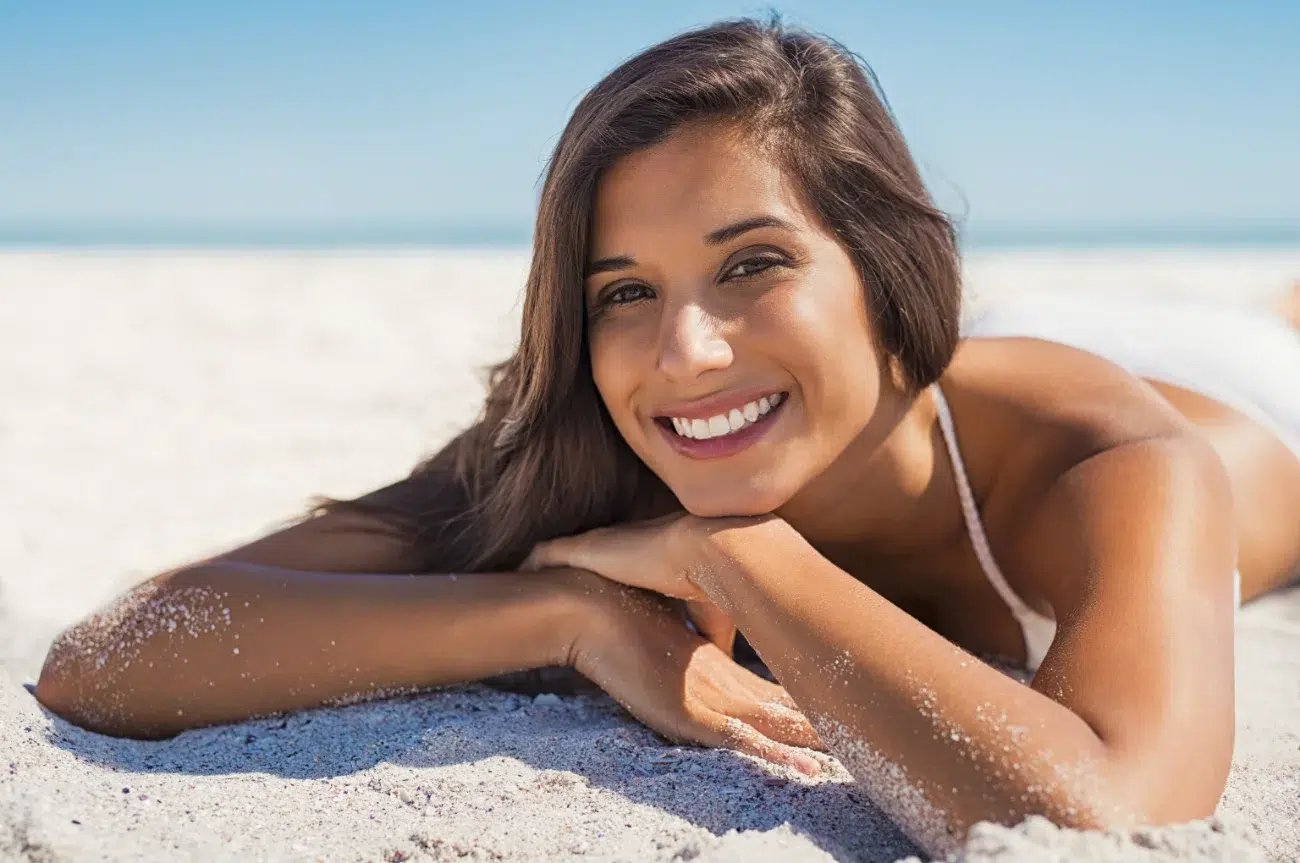 Smiling woman lying on sand pico