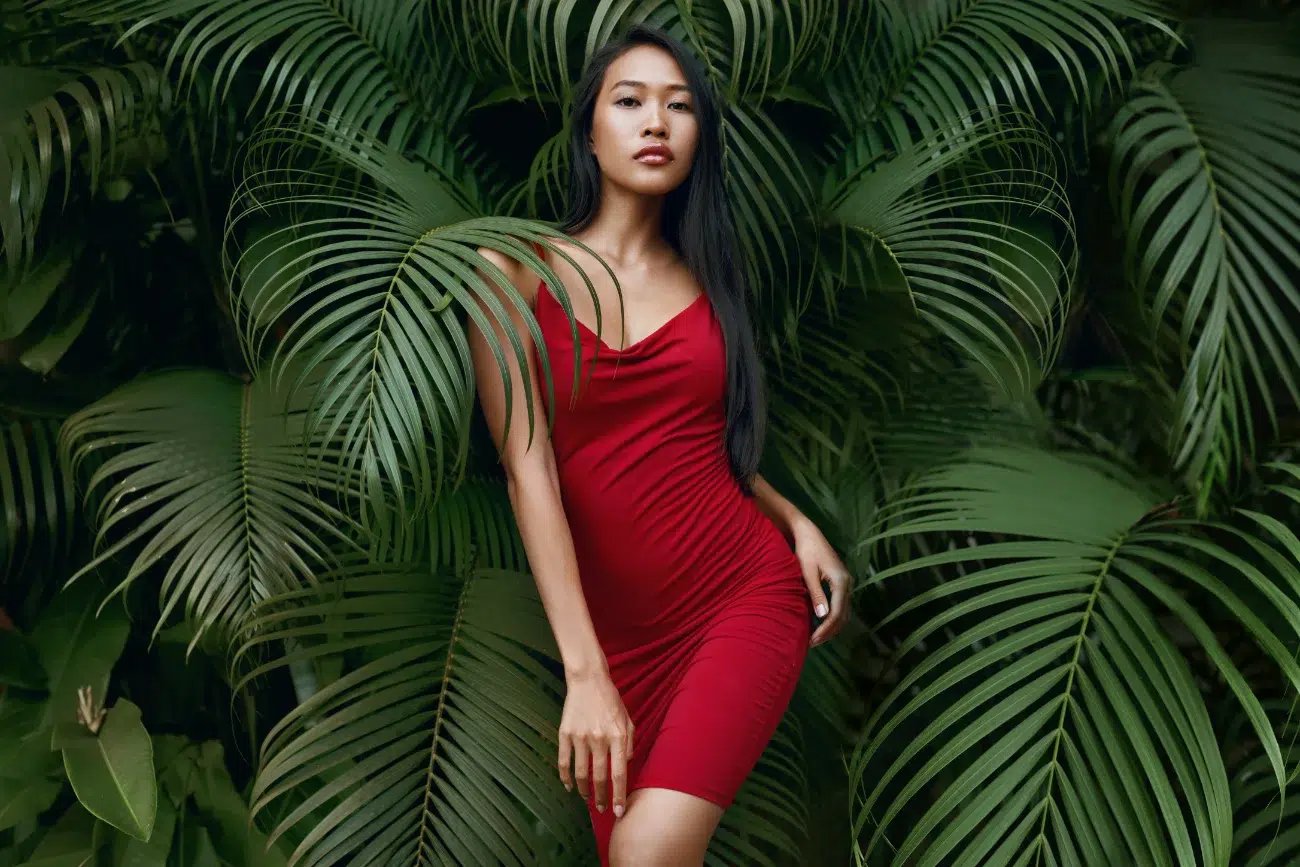 woman model in red dress with green palm leaves