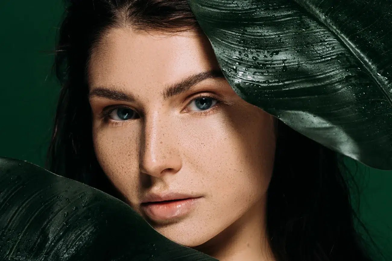 woman peeking out from a leaf